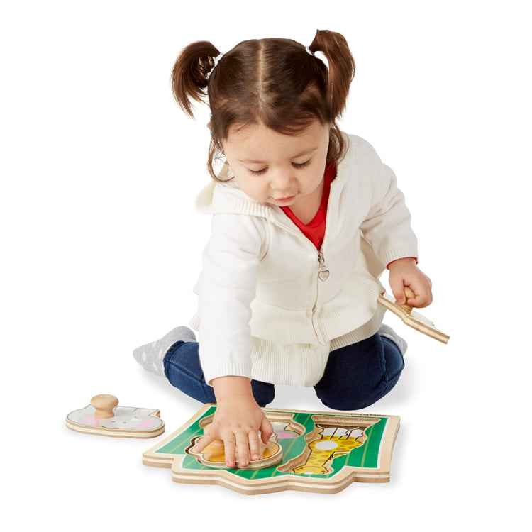 A child on white background with the Melissa & Doug Jungle Friends Safari Animals Jumbo Knob Wooden Puzzle