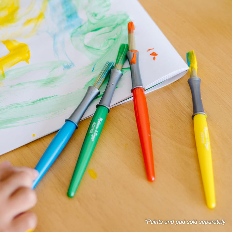 A kid playing with the Melissa & Doug Large Paint Brush Set With 4 Kids' Paint Brushes