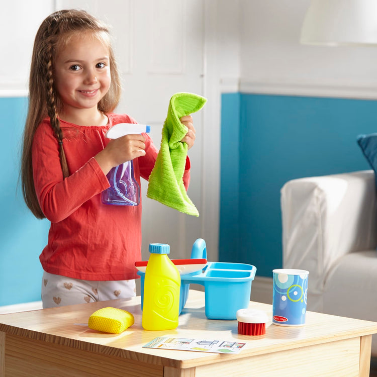 A kid playing with the Melissa & Doug Spray, Squirt & Squeegee Play Set - Pretend Play Cleaning Set