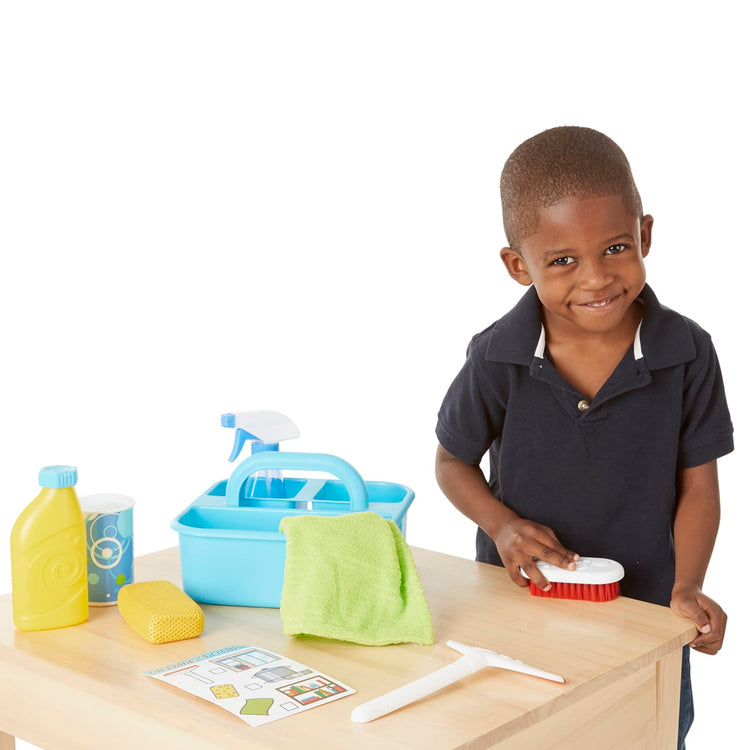 A child on white background with the Melissa & Doug Spray, Squirt & Squeegee Play Set - Pretend Play Cleaning Set