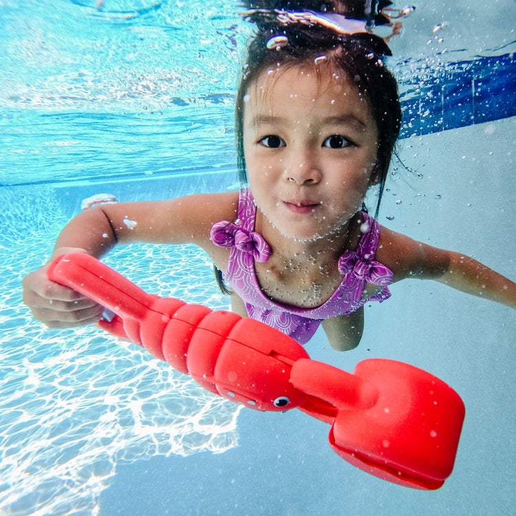 A kid playing with the Melissa & Doug Sunny Patch Louie Lobster Claw Catcher - Grab-and-Squeeze Pool Toy