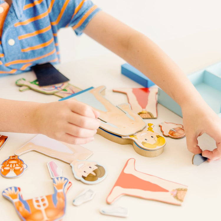 A kid playing with the Melissa & Doug Magnetic Human Body Anatomy Play Set With 24 Magnetic Pieces and Storage Tray