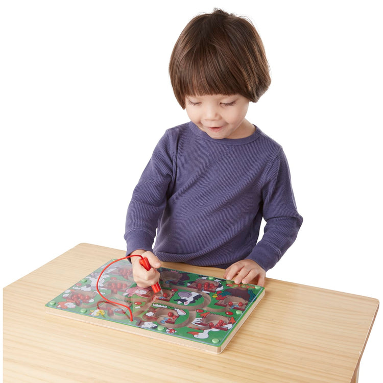 A child on white background with the Melissa & Doug Magnetic Wand Number Maze - Wooden Puzzle Activity