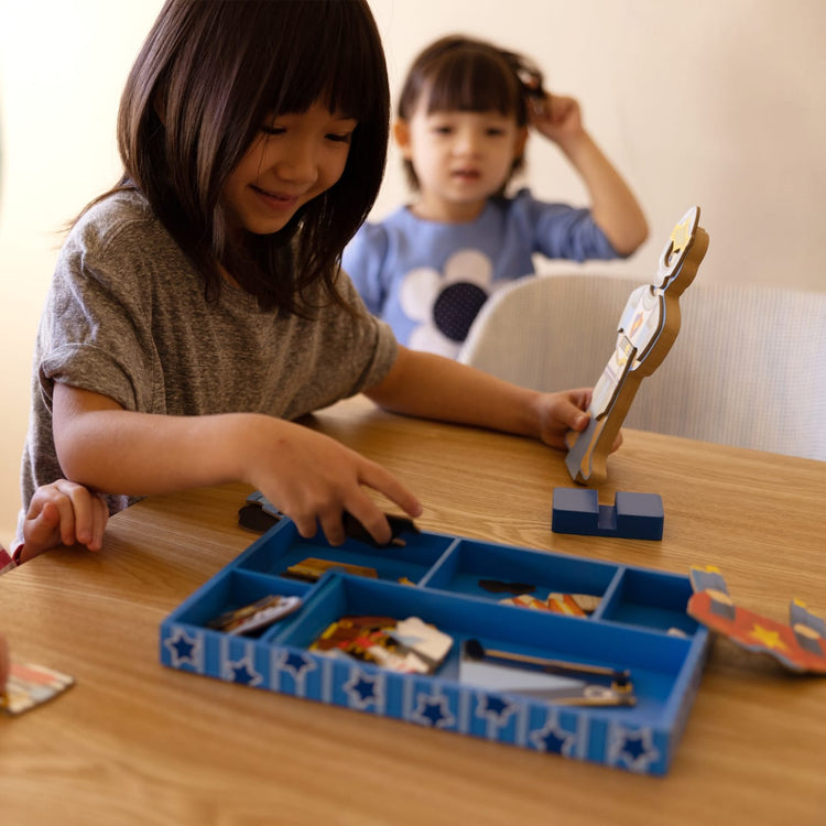 A kid playing with the Melissa & Doug Joey Magnetic Wooden Dress-Up Pretend Play Set (25+ pcs)