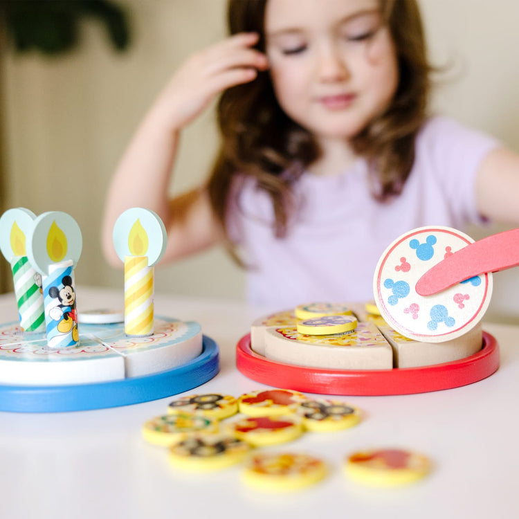 A kid playing with the Melissa & Doug Mickey Mouse Wooden Pizza and Birthday Cake Set (32 pcs) - Play Food