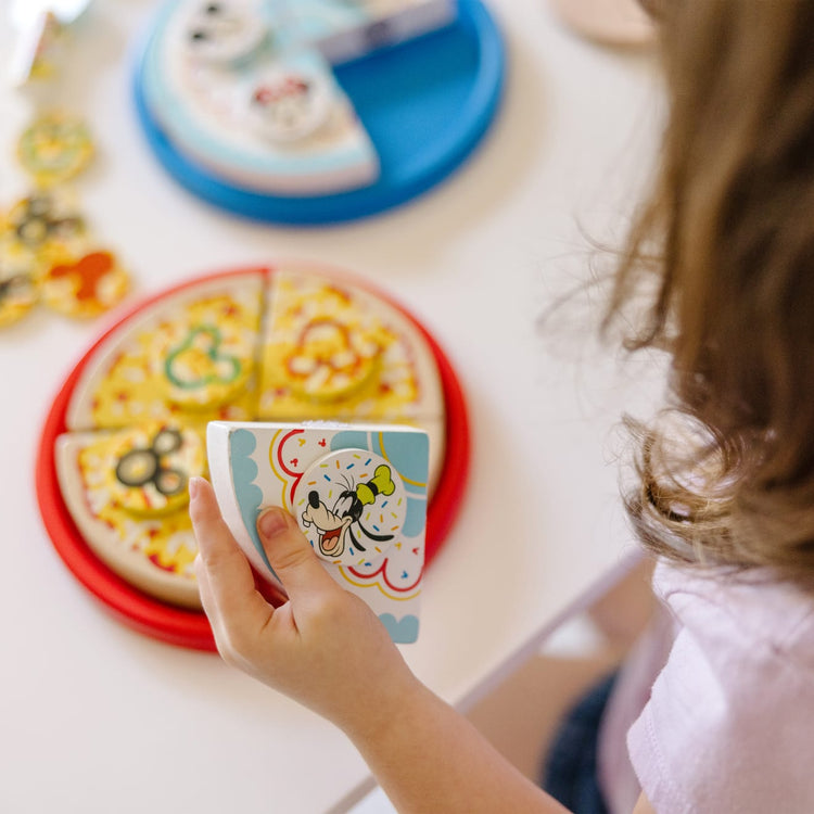 A kid playing with the Melissa & Doug Mickey Mouse Wooden Pizza and Birthday Cake Set (32 pcs) - Play Food