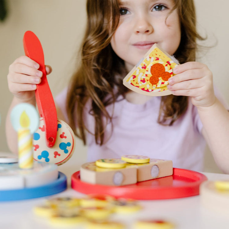 A kid playing with the Melissa & Doug Mickey Mouse Wooden Pizza and Birthday Cake Set (32 pcs) - Play Food