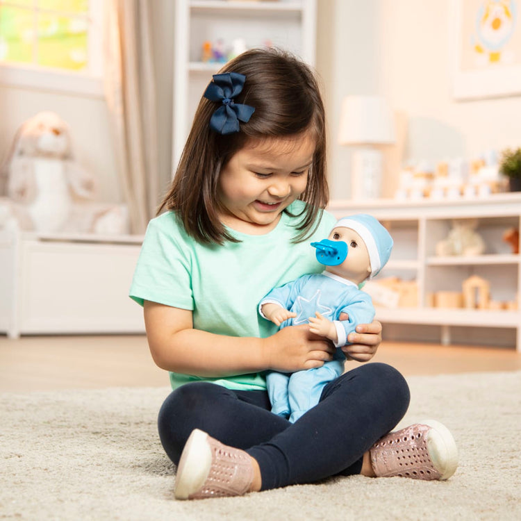 A kid playing with the Melissa & Doug Mine to Love Jordan 12” Light Skin-Tone Boy Baby Doll with Romper, Cap, Pacifier