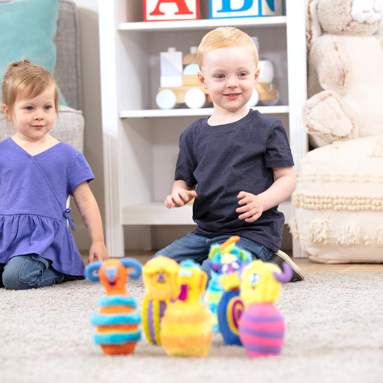 A kid playing with the Melissa & Doug Fuzzy Monster Bowling Pins & Ball With Mesh Storage Bag (8-Piece Set)