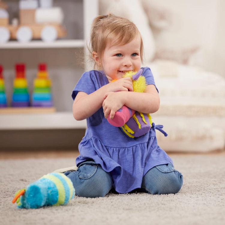 A kid playing with the Melissa & Doug Fuzzy Monster Bowling Pins & Ball With Mesh Storage Bag (8-Piece Set)