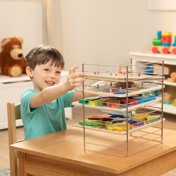 The front of the box for the Melissa & Doug Multi-Fit Metal Wire Puzzle Rack For Up To a Dozen 12-Inch-Wide, 0.75-Inch Deep Wooden Puzzles