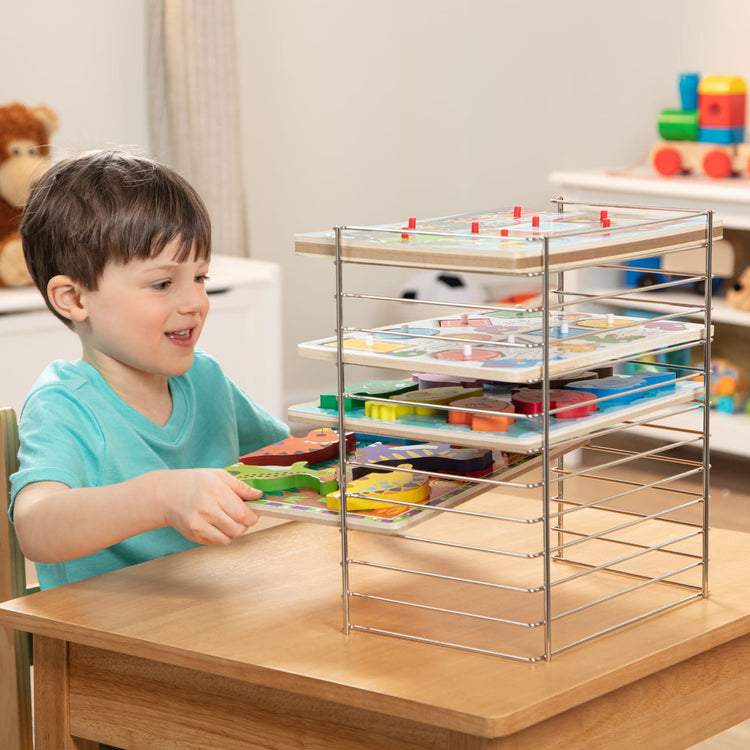 The front of the box for the Melissa & Doug Multi-Fit Metal Wire Puzzle Rack For Up To a Dozen 12-Inch-Wide, 0.75-Inch Deep Wooden Puzzles