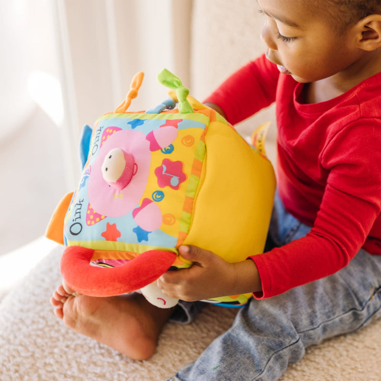 A kid playing with the Melissa & Doug K's Kids Musical Farmyard Cube Educational Baby Toy