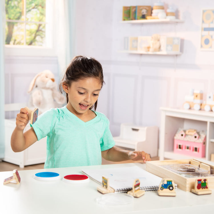 A kid playing with the Melissa & Doug My First Wooden Stamp Set - Vehicles