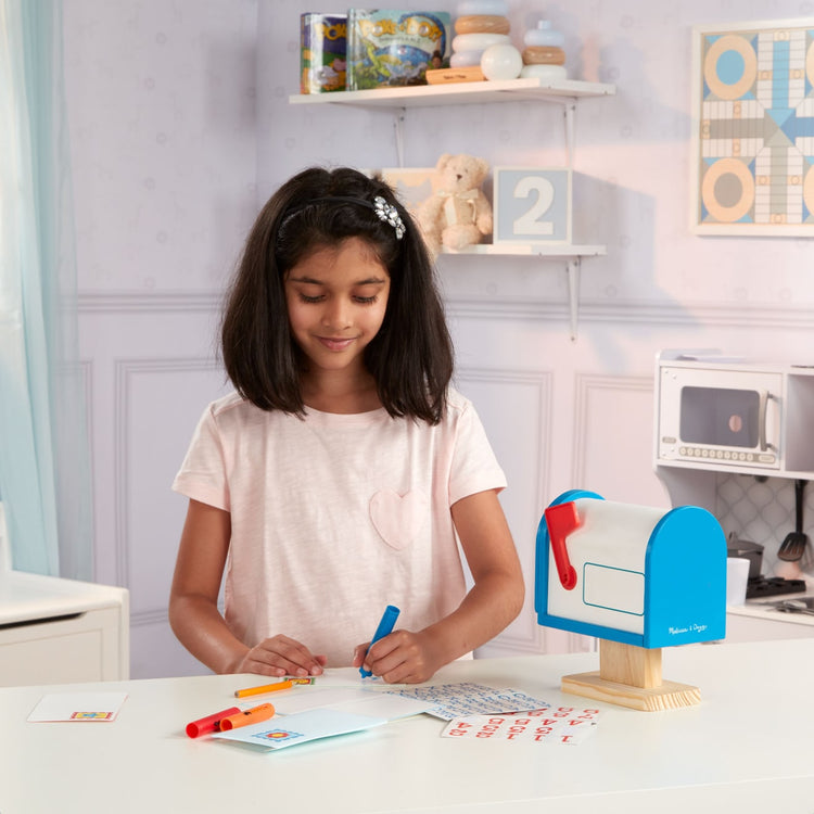 A kid playing with the Melissa & Doug My Own Wooden Mailbox Activity Set and Educational Toy