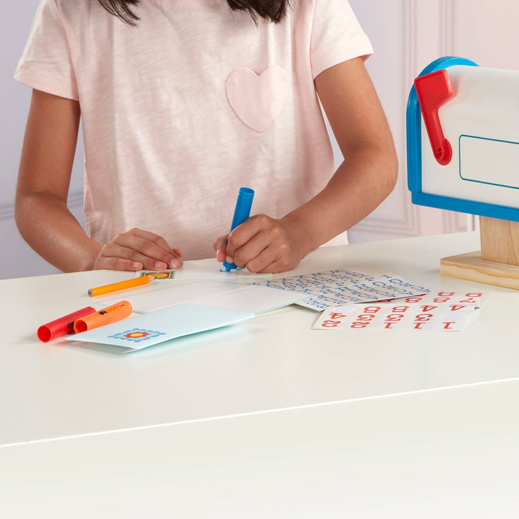 A kid playing with the Melissa & Doug My Own Wooden Mailbox Activity Set and Educational Toy