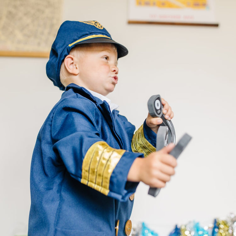 A kid playing with the Melissa & Doug Pilot Costume Role Play Set (6 pcs) - Jacket, Tie, Hat, Wings, Steering Yoke, Checklist