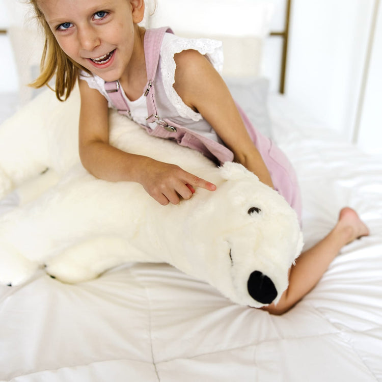 A kid playing with the Melissa & Doug Giant Polar Bear - Lifelike Stuffed Animal (nearly 3 feet long)