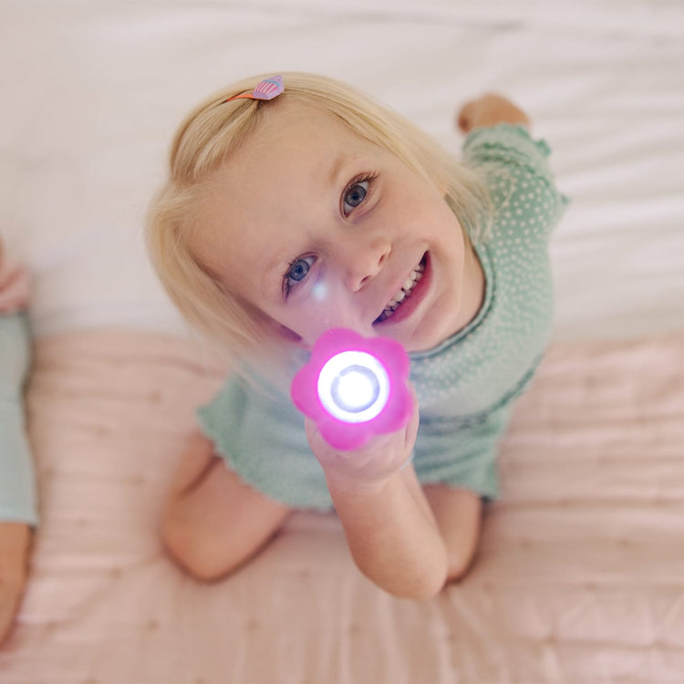 A kid playing with the Melissa & Doug Sunny Patch Pretty Petals Flower Flashlight for Kids