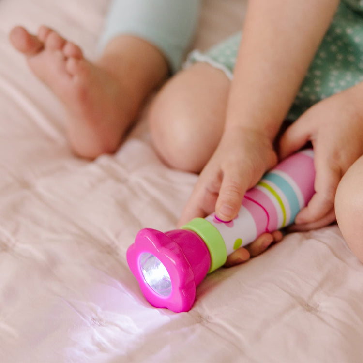 A kid playing with the Melissa & Doug Sunny Patch Pretty Petals Flower Flashlight for Kids