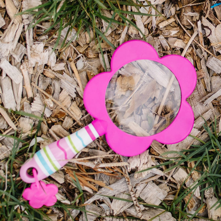 A kid playing with the Melissa & Doug Sunny Patch Pretty Petals Flower Magnifying Glass With Shatterproof Lens