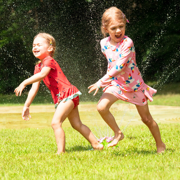 A kid playing with the Melissa & Doug Sunny Patch Pretty Petals Flower Sprinkler Toy With Hose Attachment