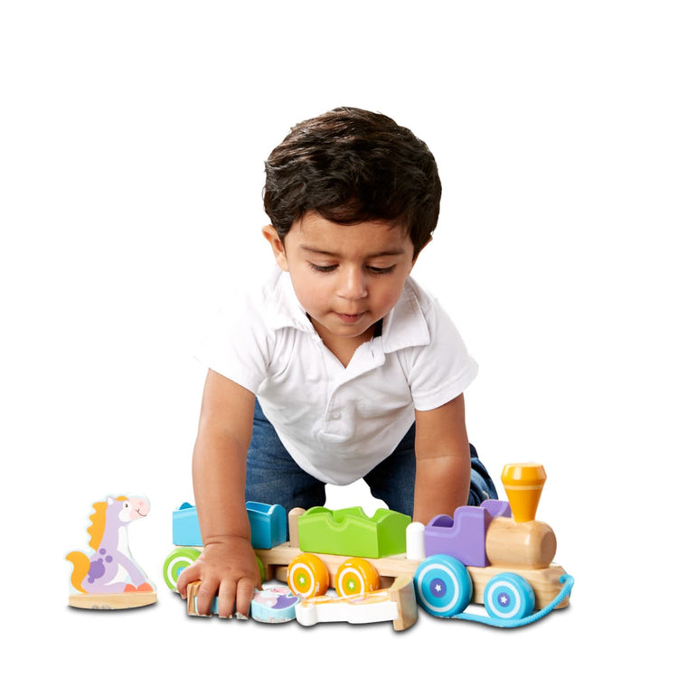 A child on white background with the Melissa & Doug First Play Wooden Rocking Farm Animals Pull Train