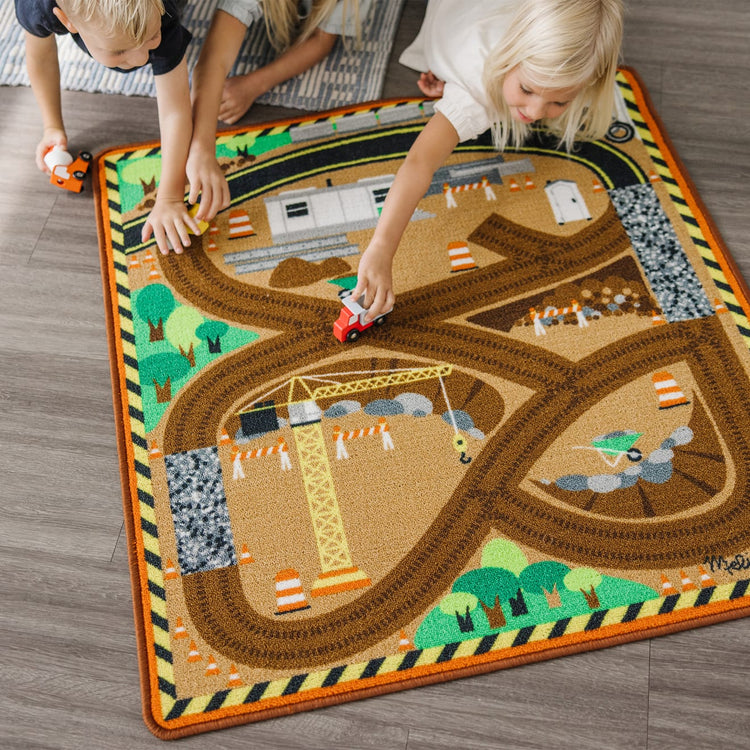 A kid playing with the Melissa & Doug Round the Construction Zone Work Site Rug With 3 Wooden Trucks (39 x 36 inches)