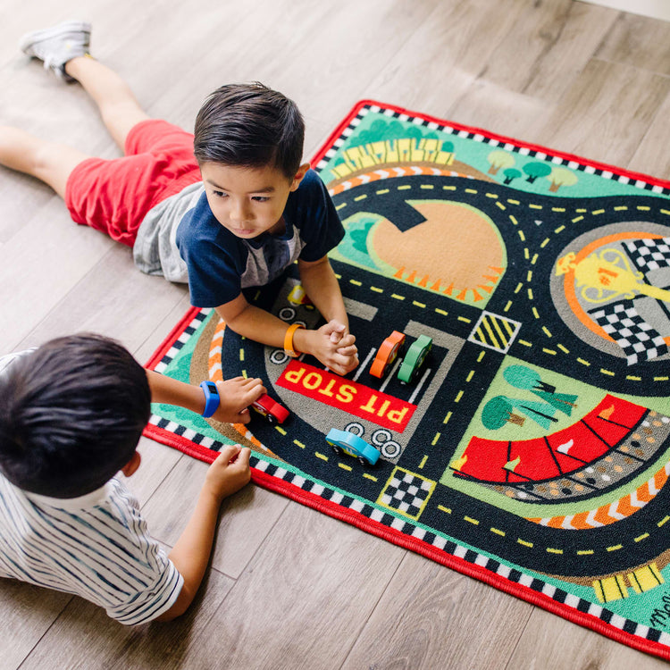 A kid playing with the Melissa & Doug Round the Speedway Race Track Rug With 4 Race Cars (39 x 36 inches)