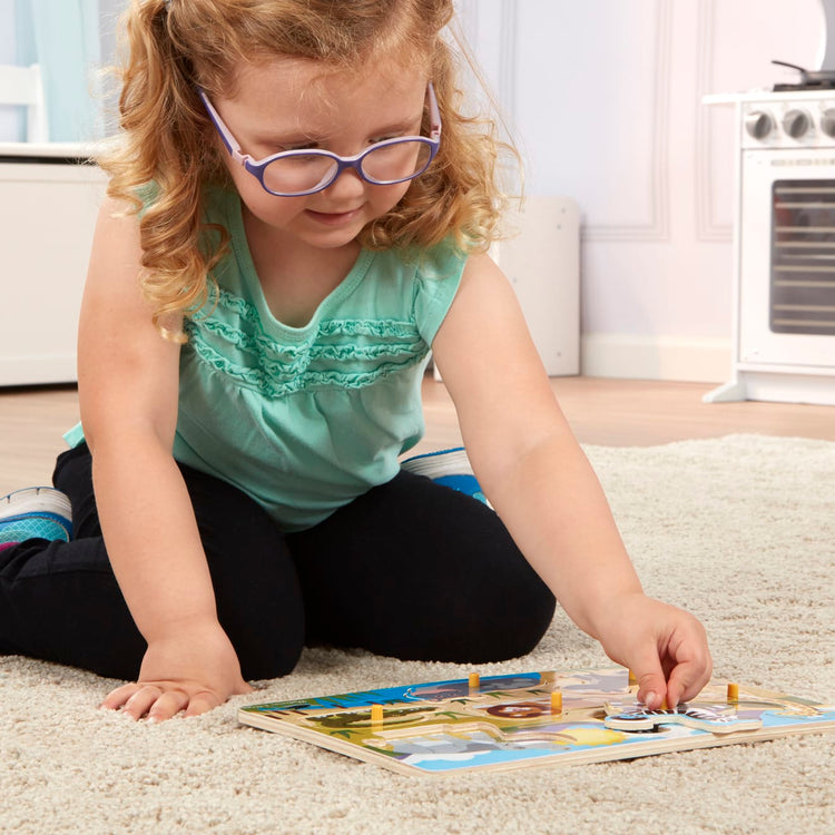 A kid playing with the Melissa & Doug Safari Wooden Peg Puzzle (7 pcs)