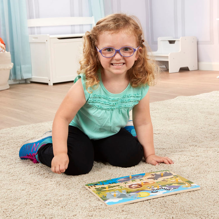 A kid playing with the Melissa & Doug Safari Wooden Peg Puzzle (7 pcs)