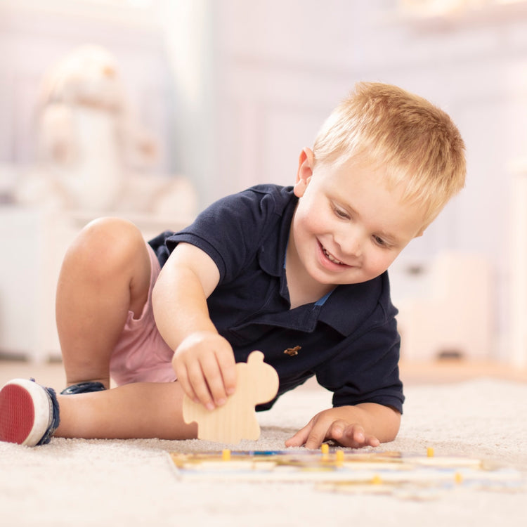 A kid playing with the Melissa & Doug Safari Wooden Peg Puzzle (7 pcs)