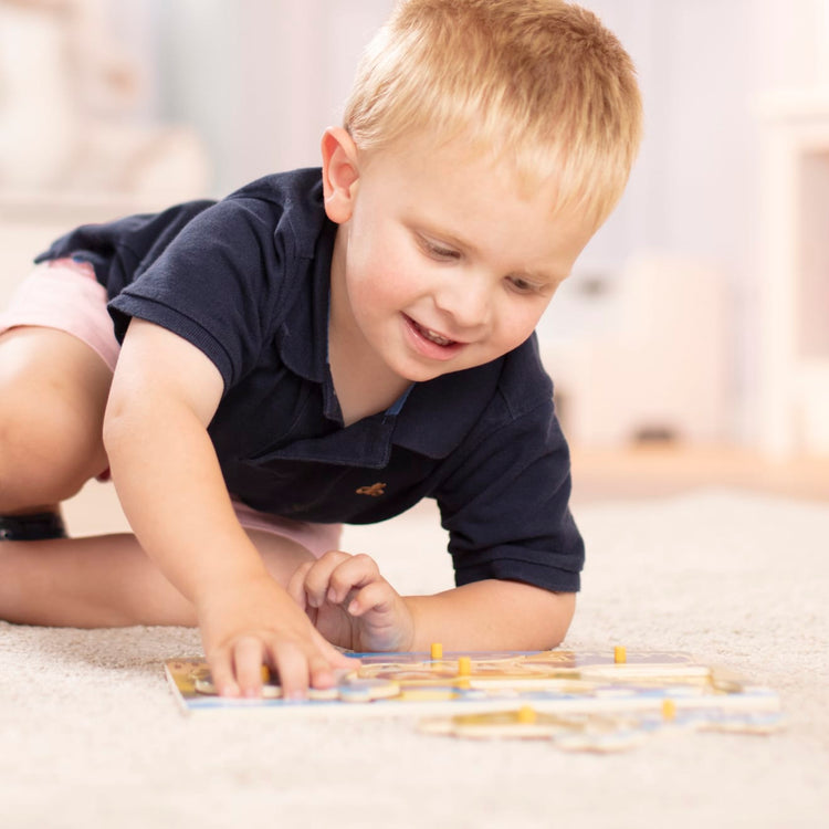 A kid playing with the Melissa & Doug Safari Wooden Peg Puzzle (7 pcs)