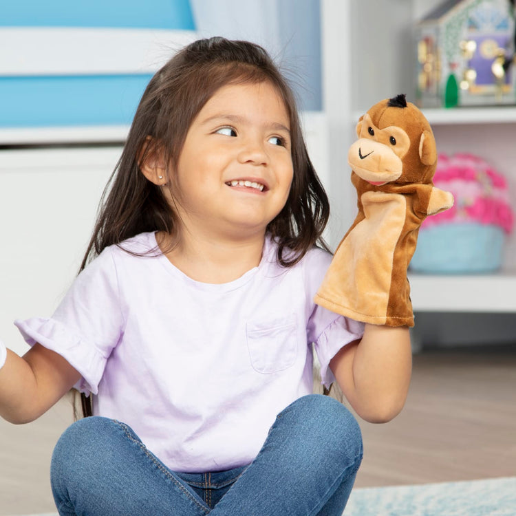 A kid playing with the Melissa & Doug Safari Buddies Hand Puppets, Set of 6 (Elephant, Tiger, Parrot, Giraffe, Monkey, Zebra)