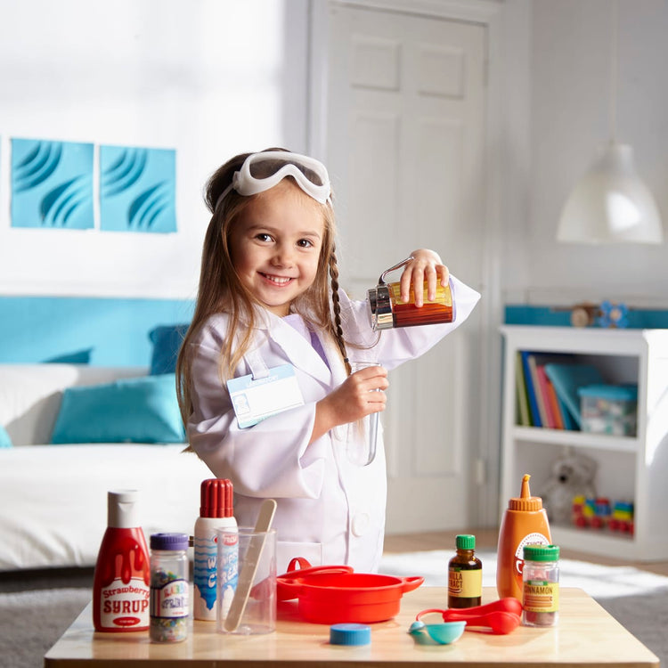 A kid playing with the Melissa & Doug Scientist Role Play Costume Set (X pcs) - Lab Coat, Goggles, 6 Experiments