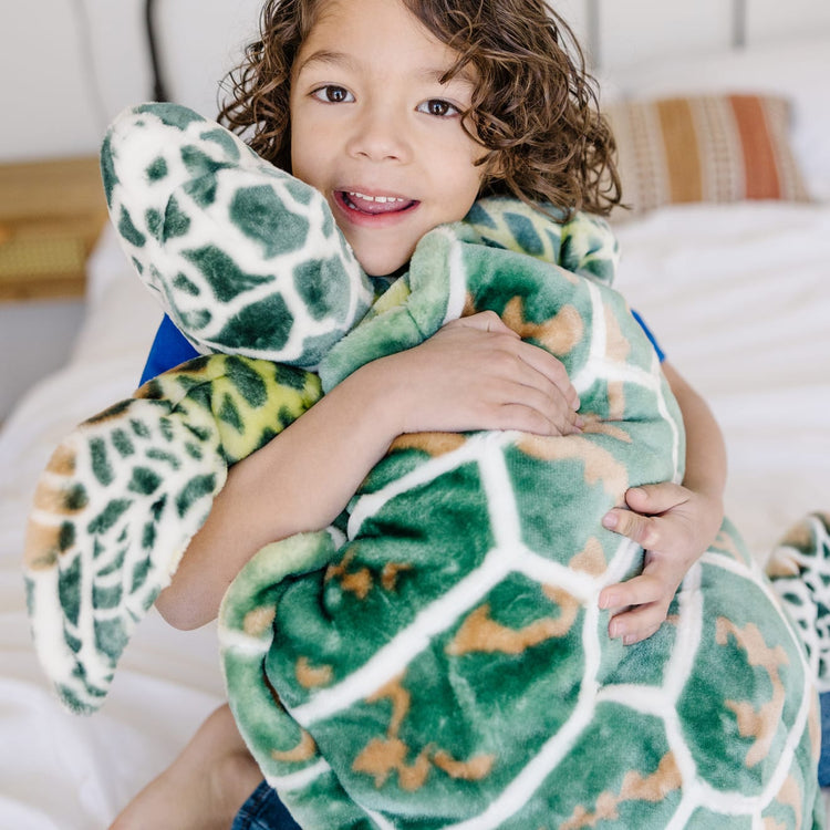 A kid playing with the Melissa & Doug Giant Sea Turtle - Lifelike Stuffed Animal (nearly 3 feet long)