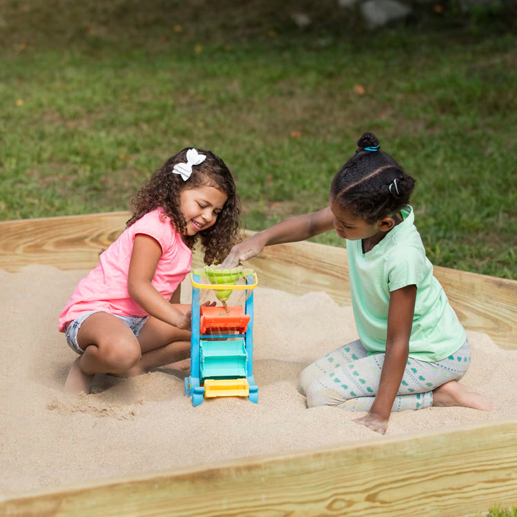 A kid playing with the Melissa & Doug Seaside Sidekicks Sand-and-Water Sifting Funnel