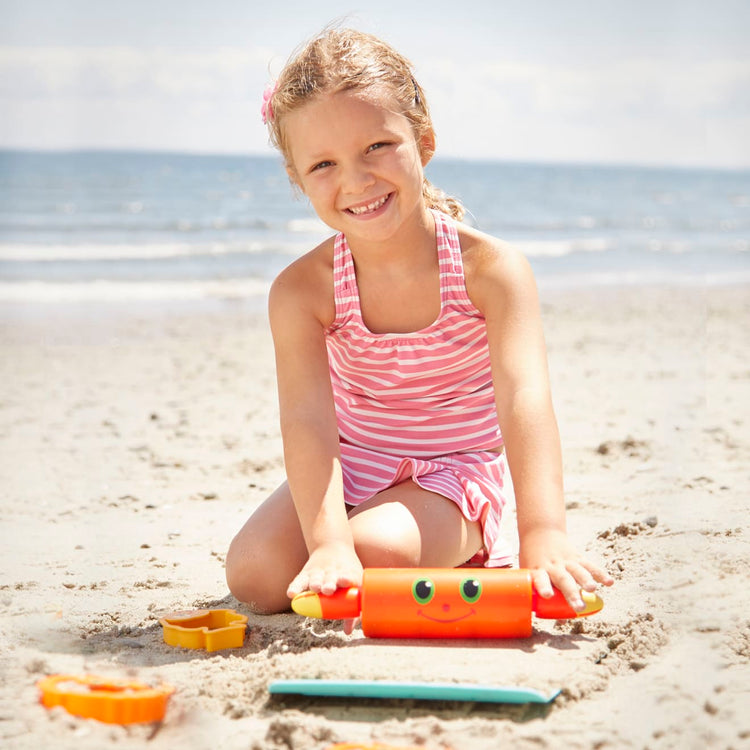 A kid playing with the Melissa & Doug Sunny Patch Seaside Sidekicks Sand Cookie-Baking Set