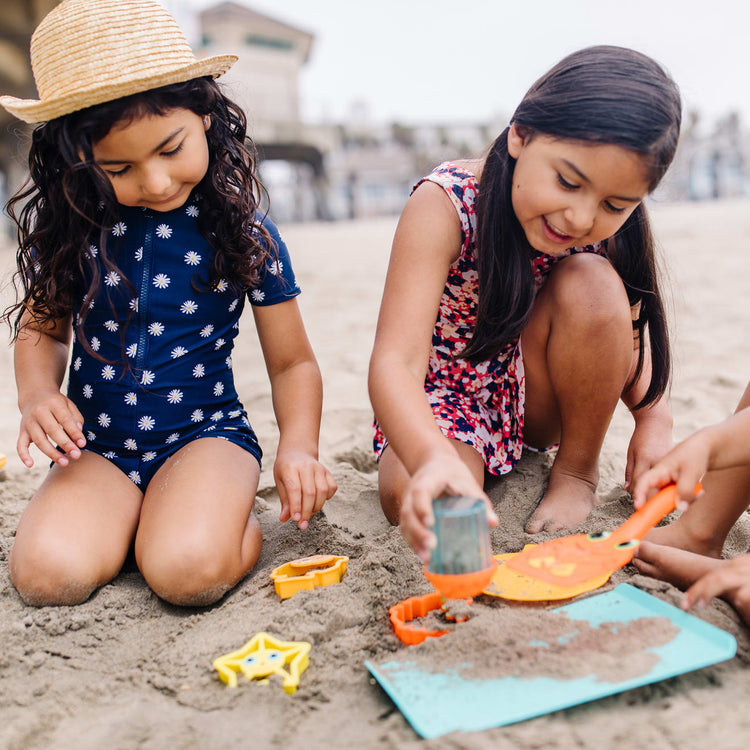 A kid playing with the Melissa & Doug Sunny Patch Seaside Sidekicks Sand Cookie-Baking Set