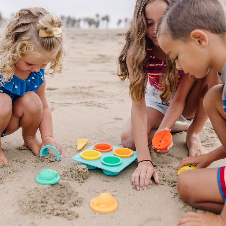 A kid playing with the Melissa & Doug Sunny Patch Seaside Sidekicks Sand Cupcake Play Set