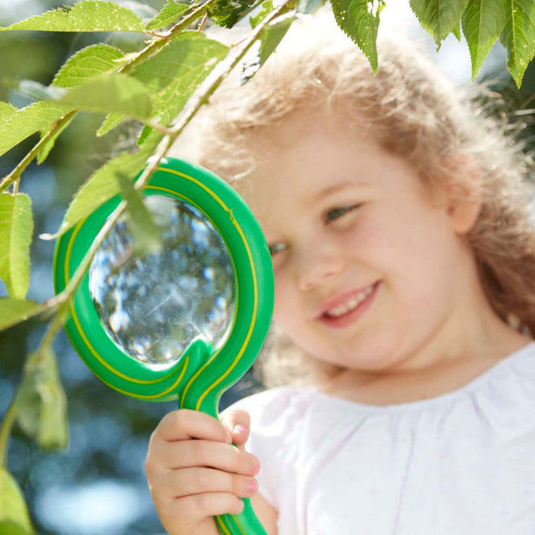 A kid playing with the Melissa & Doug Sunny Patch Shimmy Snake Magnifying Glass With Shatterproof Lens