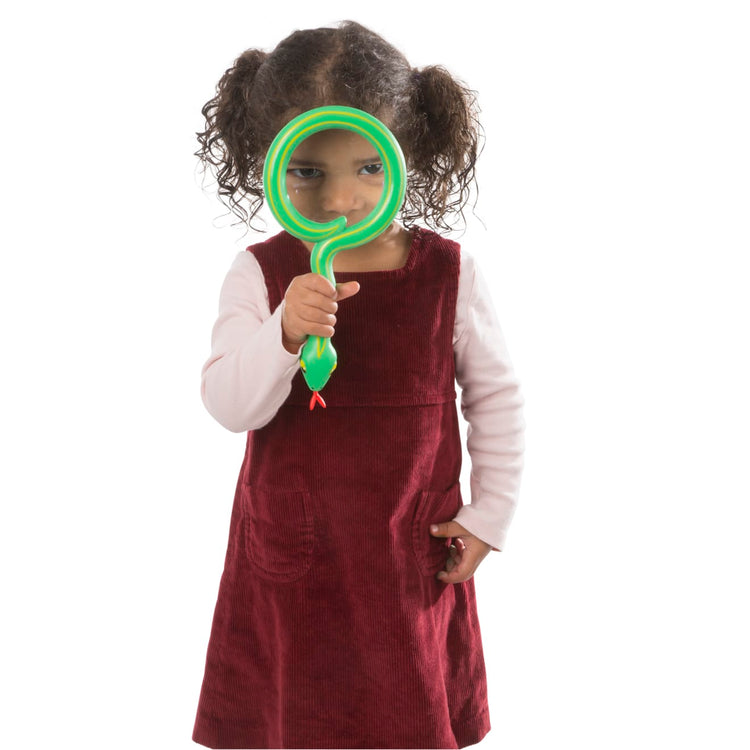 A child on white background with the Melissa & Doug Sunny Patch Shimmy Snake Magnifying Glass With Shatterproof Lens