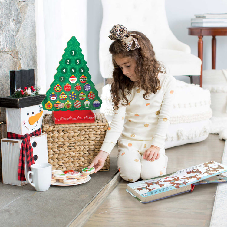 A kid playing with the Melissa & Doug Slice and Bake Wooden Christmas Cookie Play Food Set