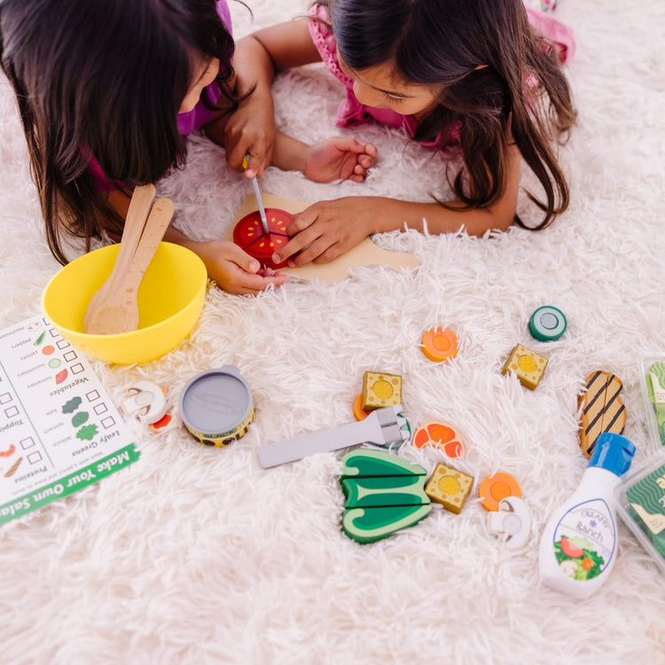 A kid playing with the Melissa & Doug Slice and Toss Salad Play Food Set – 52 Wooden and Felt Pieces