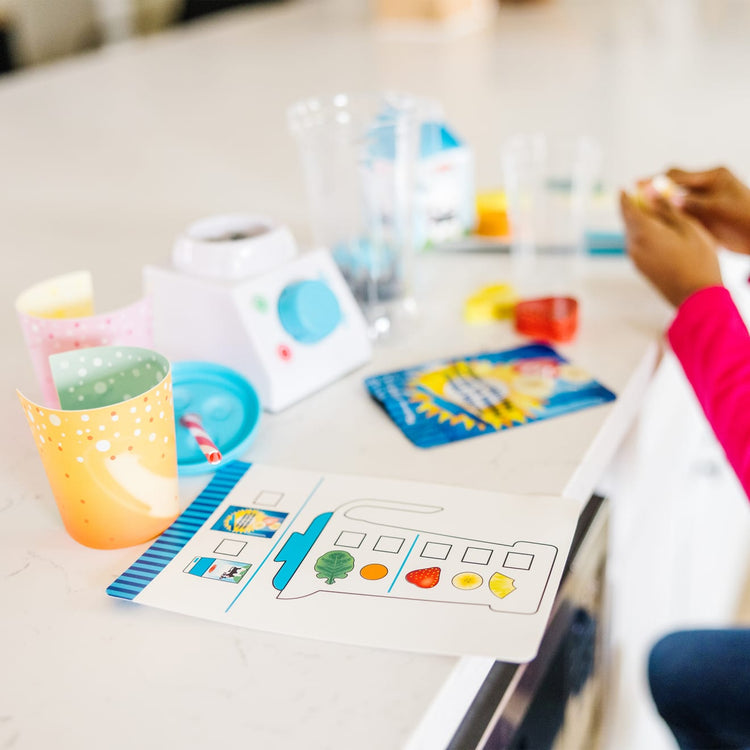 A kid playing with the Melissa & Doug Smoothie Maker Blender Set with Play Food (222 Pcs)