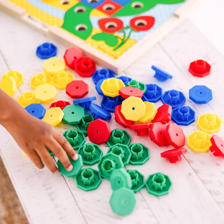 A kid playing with the Melissa & Doug Sort and Snap Color Match - Sorting and Patterns Educational Toy