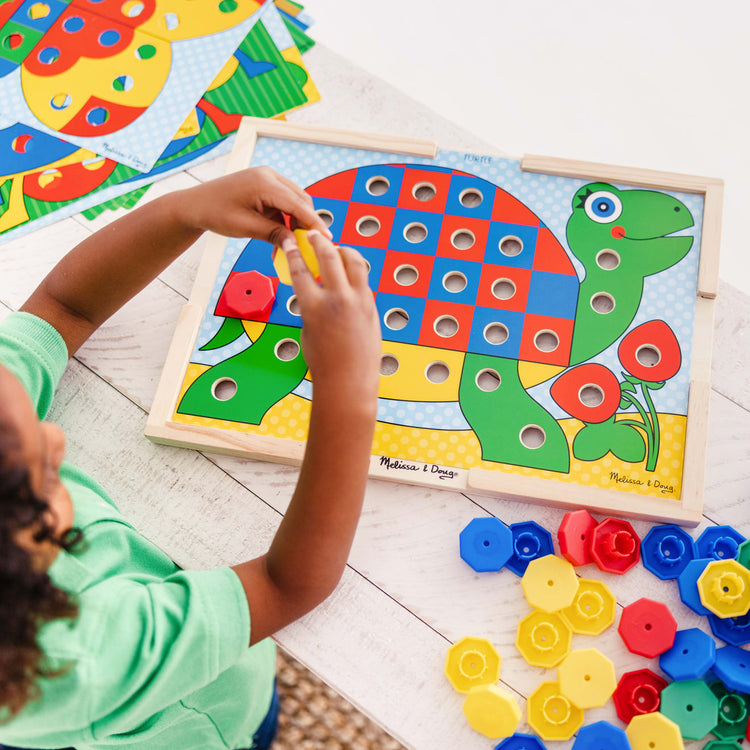 A kid playing with the Melissa & Doug Sort and Snap Color Match - Sorting and Patterns Educational Toy