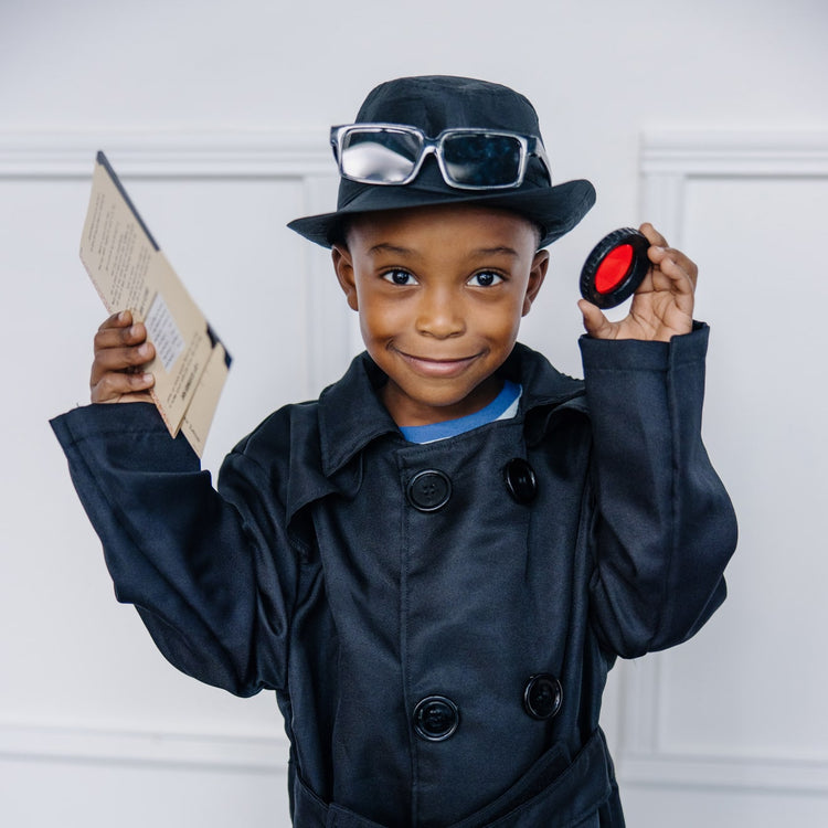 A kid playing with the Melissa & Doug Spy Costume Role Play Set