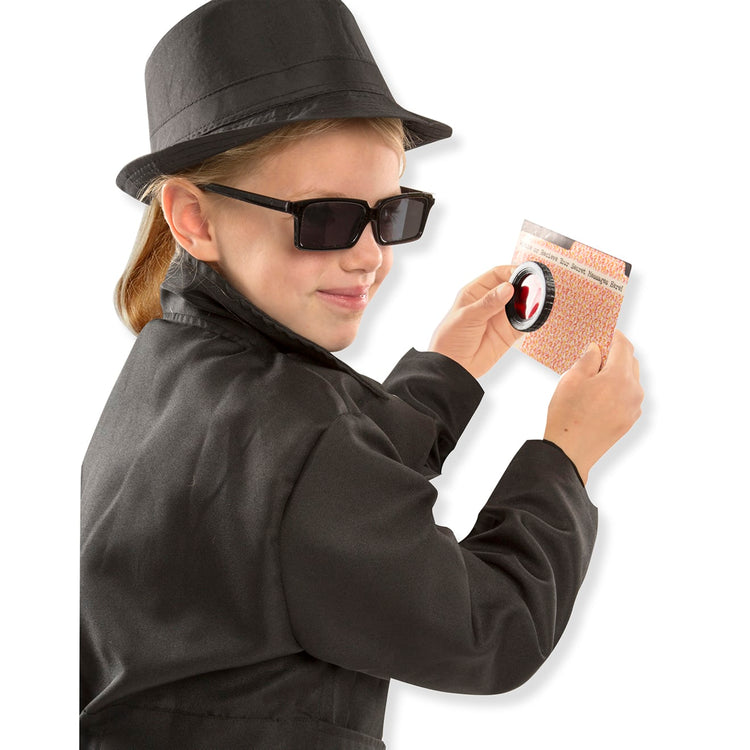 A child on white background with the Melissa & Doug Spy Costume Role Play Set