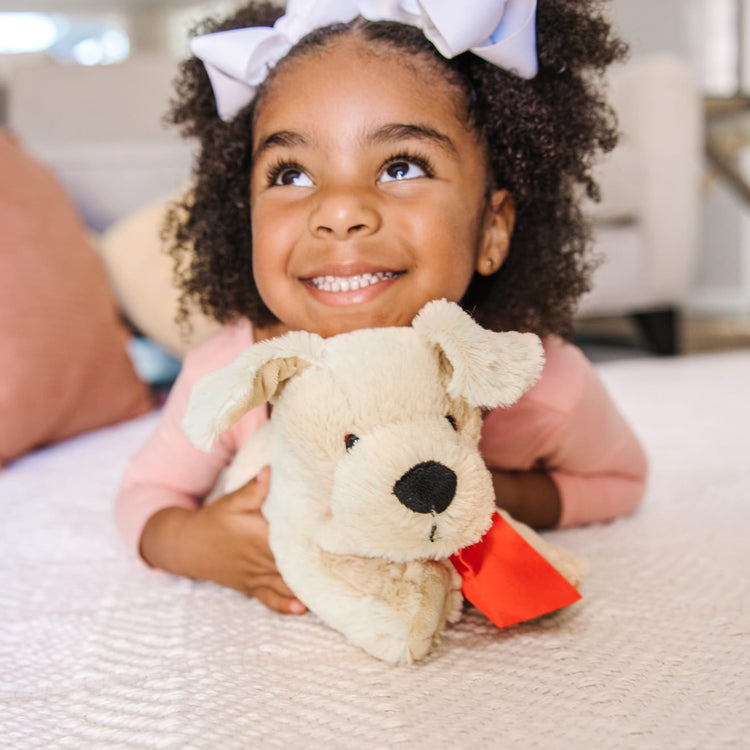 A kid playing with the Melissa & Doug Sunny Yellow Lab - Stuffed Animal Puppy Dog